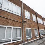 Commercial white windows installed by First Windows with emergency ladder