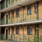 Cedar House Commercial black windows installed by First Windows with green railing