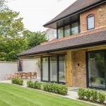 Patio doors on modern 3 story house with chairs