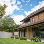 Patio doors installed on modern 3 story house with grass garden
