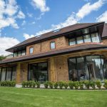 Patio doors installed on modern 3 story house - back garden view