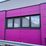 Commercial black windows installed by First Windows with pink walls